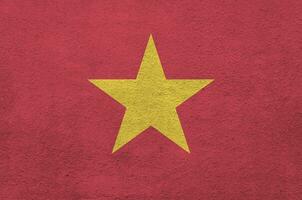 Vietnam flag depicted in bright paint colors on old relief plastering wall. Textured banner on rough background photo