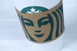 Jarkov, Ucrania - marzo 15, 2021 Starbucks taza con verde logo. Starbucks sociedad es multinacional cadena de cafeterias con sede en Seattle, Washington foto