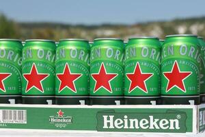 KHARKOV, UKRAINE - JULY 31, 2021 Green tin cans of Heineken lager beer produced by the Dutch brewing company Heineken N.V. photo