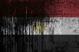 Egypt flag depicted in paint colors on old and dirty oil barrel wall closeup. Textured banner on rough background photo
