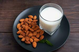 Almond milk in glass glasses on a dark wooden background. Copy space. photo