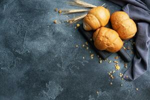Fresh wheat bread rolls. Rolls for a hot dog or hamburger. Dark background copy space. photo
