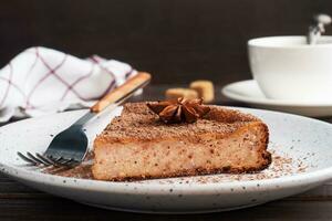 Slice of chocolate curd casserole on a plate, a portion piece of cake with chocolate and coffee. Dark wooden rustic background. copy space photo