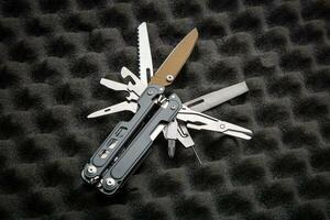 Modern universal army multitool. A tool for all occasions. Gray foam back photo