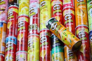 KHARKOV, UKRAINE - MARCH 30, 2021 Many Pringles cylinder chips boxes with varios colors and flavours. American brand of stackable potato-based crisps photo