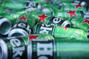 KHARKOV, UKRAINE - JULY 31, 2021 Green tin cans of Heineken lager beer produced by the Dutch brewing company Heineken N.V. photo