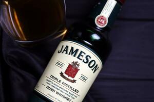 KHARKOV, UKRAINE - DECEMBER 3, 2020 Jameson triple distilled irish whiskey bottle on dark black background. Elite alcohol photo
