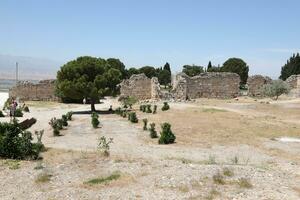 ANTALYA, TURKEY - MAY 15, 2021 Ruins of ancient city Hierapolis near Pamukkale, Turkey at sunny day. Parts of old historical buildings with big blocks photo