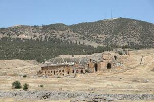 ANTALYA, TURKEY - MAY 15, 2021 Ruins of ancient city Hierapolis near Pamukkale, Turkey at sunny day. Parts of old historical buildings with big blocks photo