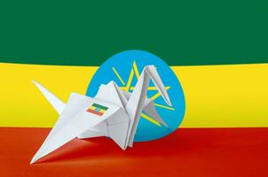 Ethiopia flag depicted on paper origami crane wing. Handmade arts concept photo