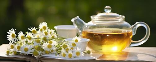 Chamomile flowers, books, a glass teapot, and a cup of herbal tea on a table closeup. Generative AI photo