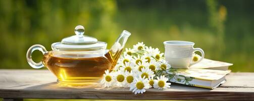 manzanilla flores, libros, un vaso tetera, y un taza de herbario té en un mesa de cerca. generativo ai foto