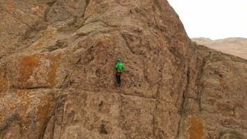 homem alpinista Rocha escalando. falésias dentro Tamgaly tas, Cazaquistão. aéreo visualizar. órbita video