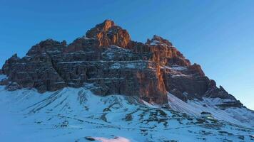 Tre Cime Di Lavaredo. The Three Peaks at Sunrise in Winter and Auronzo Hut. Aerial View. Sexten Dolomites, South Tyrol. Italy. Orbiting. View from the South video