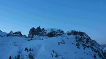 Kadini di Misurina Berge beim Winter Morgen Dämmerung. Blau Stunde. Antenne Sicht. sexten Dolomiten, Belluno, Italien. Drohne fliegt nach oben, Neigung runter. Kran Schuss video