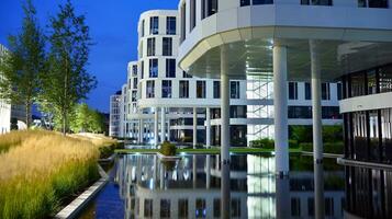 Pattern of office buildings windows illuminated at night. Glass architecture ,corporate building at night - business concept. photo