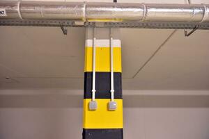 Typical underground car parking garage in a modern apartment house. Interior pillars painted yellow. photo