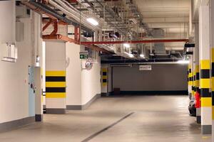 Typical underground car parking garage in a modern apartment house. Interior pillars painted yellow. photo