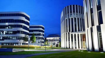 Pattern of office buildings windows illuminated at night. Glass architecture ,corporate building at night - business concept. photo