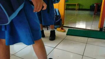 magelang, indonesia.11 06 2023.a grupo de alegre indonesio rural colegio niños o niños vistiendo uniformes y mochilas dejando o corriendo fuera de el salón de clases después colegio es encima, video