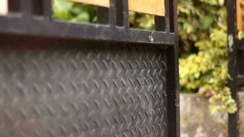 Open the metal fence gate of the house by pushing to make the house security video