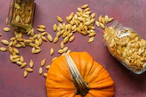 dos frascos con calabaza semillas en un rústico mesa foto