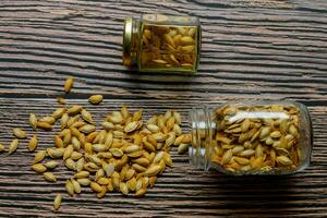 Two jars with pumpkin seeds on a rustic table photo