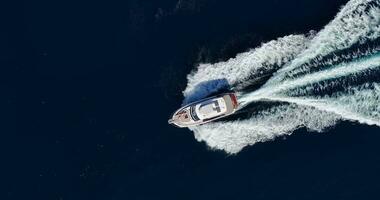 Vertical drone video on a moving yacht over turquoise water