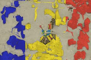 Moldova flag depicted in paint colors on old obsolete messy concrete wall closeup. Textured banner on rough background photo