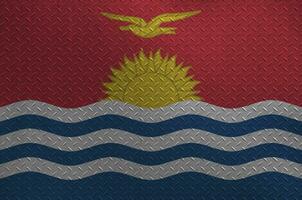 Kiribati flag depicted in paint colors on old brushed metal plate or wall closeup. Textured banner on rough background photo