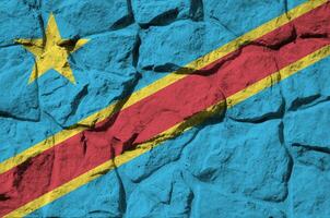 Democratic Republic of the Congo flag depicted in paint colors on old stone wall closeup. Textured banner on rock wall background photo