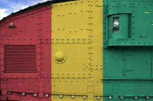 Guinea flag depicted on side part of military armored tank closeup. Army forces conceptual background photo