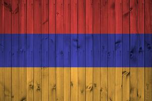 Armenia bandera representado en brillante pintar colores en antiguo de madera pared. texturizado bandera en áspero antecedentes foto
