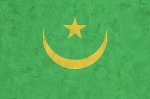 Mauritania flag depicted in bright paint colors on old relief plastering wall. Textured banner on rough background photo