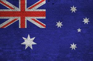 Australia flag depicted in paint colors on old brick wall. Textured banner on big brick wall masonry background photo