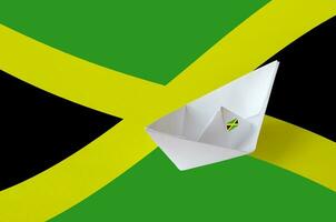Jamaica flag depicted on paper origami ship closeup. Handmade arts concept photo