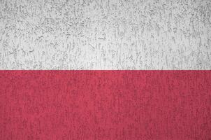 Poland flag depicted in bright paint colors on old relief plastering wall. Textured banner on rough background photo
