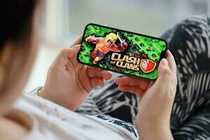 Clash of Clans mobile iOS game on iPhone 15 smartphone screen in female hands during mobile gameplay photo