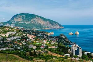 Panoramic view on city Gurzuf and Bear Mountain, Au-Dag, Crimea. Sunny day. The concept of active city in unity with nature. photo