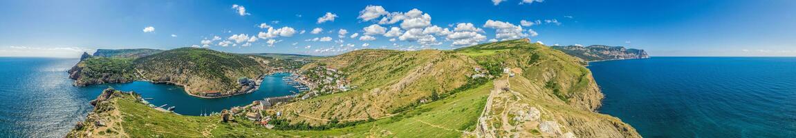 Scenic panoramic view of Balaclava bay with yachts from the ruines of Genoese fortress Chembalo. Balaklava, Sevastopol, Crimea. Inspirational travel landscape. Aerial photo. Copy space. photo