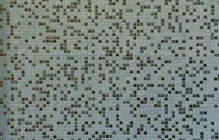 The texture of the wall, decorated with a mosaic of various small square tiles. Abstract pattern of ceramic tiles on the wall photo