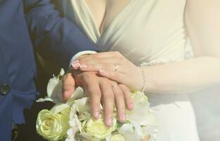 The newlywed couple is holding a beautiful wedding bouquet. Classical wedding photography, symbolizing unity, love and the creation of a new family photo