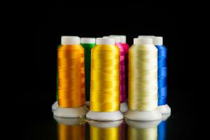 set of different color sewing threads,on black background. photo