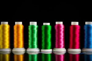 set of different color sewing threads,on black background. photo