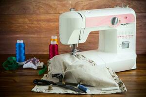de coser máquina con tela y hilos para de coser, de cerca. el trabajando proceso foto