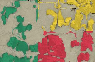 Benin flag depicted in paint colors on old obsolete messy concrete wall closeup. Textured banner on rough background photo