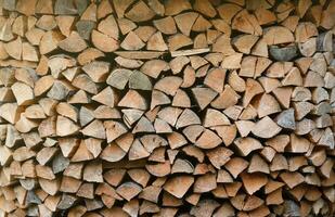 leña apilado cerca el de madera pared de antiguo cabaña. muchos Cortado registros de leña foto