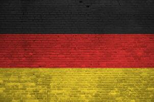 Germany flag depicted in paint colors on old brick wall. Textured banner on big brick wall masonry background photo