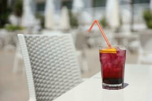 Pink and red Fresh colorful exotic alcoholic cocktail with lemon and ice on restaurant table. Colorful pink Soft drink with ice photo