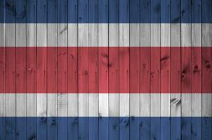 Costa Rica flag depicted in bright paint colors on old wooden wall. Textured banner on rough background photo